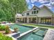 Beautiful backyard with pool, spa, covered patio, outdoor kitchen and lush landscaping at 100 Verbena Ct, Weddington, NC 28173