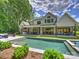 Expansive backyard with a pristine pool, outdoor kitchen, and covered seating areas at 100 Verbena Ct, Weddington, NC 28173
