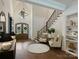 Bright foyer featuring hardwood floors, elegant lighting, and an open staircase with wood treads and a black railing at 100 Verbena Ct, Weddington, NC 28173