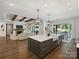 Open concept kitchen with a large island, modern fixtures, and a seamless flow into the living and dining areas at 100 Verbena Ct, Weddington, NC 28173