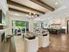 Open-concept living room with wood beams, fireplace, and access to the backyard, seamlessly connecting to the kitchen at 100 Verbena Ct, Weddington, NC 28173