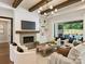 Bright living room features a fireplace, wood beams, modern lighting, and an open flow to an outdoor living space at 100 Verbena Ct, Weddington, NC 28173