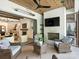 Outdoor living space with fireplace, TV, ceiling fan, and comfortable seating area with view into the home at 100 Verbena Ct, Weddington, NC 28173