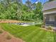 Lush backyard view showcasing a modern pool, landscaping, and inviting lounge chairs at 100 Verbena Ct, Weddington, NC 28173