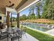 Inviting covered patio with dining area overlooking a modern pool and lush landscaping at 100 Verbena Ct, Weddington, NC 28173
