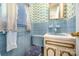 Retro blue bathroom with matching blue fixtures, blue tile, and floral wallpaper accents at 1012 Hawkinstown Rd, Salisbury, NC 28144