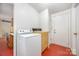 Functional laundry room with vintage washer, dryer, and linoleum flooring adjacent to back entrance at 1012 Hawkinstown Rd, Salisbury, NC 28144