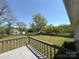 Large backyard features green grass, mature trees, and a wooden deck at 107 Plumtree Dr, Kings Mountain, NC 28086