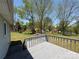 Large backyard features green grass, mature trees, a play set, and a wooden deck at 107 Plumtree Dr, Kings Mountain, NC 28086