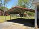 View of the house's large carport, offering ample covered parking space and access to the fenced backyard at 107 Plumtree Dr, Kings Mountain, NC 28086