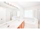 Bright bathroom featuring double sinks, soaking tub, and separate shower, creating a spa-like retreat at 10803 Gold Pan Rd, Charlotte, NC 28215