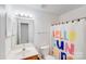 Bright bathroom features vanity, mirror, toilet and tub-shower with curtain at 10803 Gold Pan Rd, Charlotte, NC 28215
