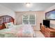 Comfortable bedroom featuring a wooden bed frame, soft carpet, and a bright window view at 10803 Gold Pan Rd, Charlotte, NC 28215