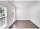 Bright, empty room with hardwood floors, large windows, and white walls, awaiting personalized decor at 10803 Gold Pan Rd, Charlotte, NC 28215