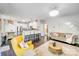 Open-concept living room featuring dark hardwood floors, yellow chair, and views of the kitchen and staircase at 10803 Gold Pan Rd, Charlotte, NC 28215