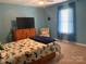 Cozy bedroom with blue walls, a ceiling fan, and a bright, butterfly-themed bedspread at 1104 Valley St, Statesville, NC 28677