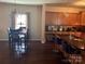 Open-concept dining and kitchen area, hardwood floors, and modern kitchen bar with chairs at 1104 Valley St, Statesville, NC 28677
