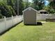 Side view of an outdoor shed in a backyard surrounded by white fencing at 1104 Valley St, Statesville, NC 28677