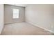 Bedroom with a window, neutral walls and carpet, creating a warm inviting space at 117 Rooster Tail Ln, Troutman, NC 28166