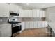 Kitchen featuring white cabinets, modern appliances, and a gas stove at 117 Rooster Tail Ln, Troutman, NC 28166