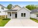 Charming one-story home featuring a covered entry, concrete driveway, and modern gray siding at 1301 Marble St, Charlotte, NC 28208