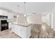 The open-concept kitchen features white cabinets, granite countertops, an island, and an open living area at 1301 Marble St, Charlotte, NC 28208