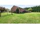 Backyard featuring a well-maintained lawn, fenced-in area, and wooden deck with outdoor seating at 131 Fieldhaven Pl, Troutman, NC 28166