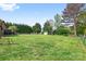Expansive backyard features lush greenery, privacy trees, and a storage shed at 131 Fieldhaven Pl, Troutman, NC 28166