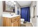 Charming bathroom features a wood vanity, matching mirror, and blue shower curtain at 131 Fieldhaven Pl, Troutman, NC 28166