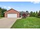 Well-maintained brick home with attached garage, landscaped front yard, and inviting entrance at 131 Fieldhaven Pl, Troutman, NC 28166