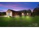 Charming brick home featuring manicured lawn, attached two-car garage, and welcoming front porch under a beautiful sunset at 131 Fieldhaven Pl, Troutman, NC 28166