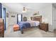 Well-lit primary bedroom with a wooden bed frame, ceiling fan, and comfortable carpet at 131 Fieldhaven Pl, Troutman, NC 28166