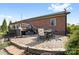 Brick patio with outdoor dining set, grill, and manicured landscaping at 131 Fieldhaven Pl, Troutman, NC 28166