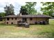 Brick home exterior with small wooden deck, grassy yard, mature trees and partial walk-out basement at 134 Piedmont Dr, Kannapolis, NC 28081