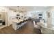 Open-concept kitchen with white cabinets, island with seating, and adjacent breakfast area at 15520 Capps Rd, Charlotte, NC 28278