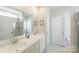 Bright bathroom featuring double sinks, a large mirror, and a glass-enclosed shower at 15520 Capps Rd, Charlotte, NC 28278