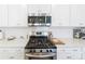 Close-up of stainless steel microwave and gas range with white subway tile backsplash at 15520 Capps Rd, Charlotte, NC 28278