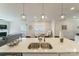 Island view of a bright, airy kitchen with stainless steel sink and modern pendant lighting at 15520 Capps Rd, Charlotte, NC 28278