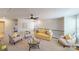 Comfortable living room with a yellow sofa, light colored chairs and a glass coffee table at 15520 Capps Rd, Charlotte, NC 28278