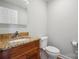 Well-lit bathroom featuring granite counters, double sinks, dark wood vanity, and a toilet at 1592 Farmington Hills Dr, Conover, NC 28613