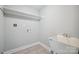 Bright laundry room with tile floors, utility sink, storage shelf, and washer/dryer hookups at 1592 Farmington Hills Dr, Conover, NC 28613