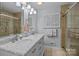Elegant bathroom with a double sink vanity, marble countertops, and glass door shower at 16070 Palawan Ct, Tega Cay, SC 29708