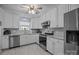 Well-equipped kitchen featuring white cabinets, stainless steel appliances, and neutral countertops at 16070 Palawan Ct, Tega Cay, SC 29708
