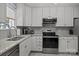 Well-lit kitchen featuring white cabinets, stainless steel appliances, and elegant granite countertops at 16070 Palawan Ct, Tega Cay, SC 29708