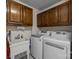 Utility room with modern washer and dryer set, bright lighting, and ample storage cabinets at 16070 Palawan Ct, Tega Cay, SC 29708