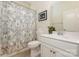 Well-lit bathroom with a white vanity, framed mirror, and shower with a patterned curtain at 1670 Tranquility Blvd, Lancaster, SC 29720