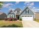 Charming two-story home with a manicured lawn, a two-car garage, and blue shingle siding at 1670 Tranquility Blvd, Lancaster, SC 29720