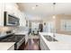 Modern kitchen with stainless steel appliances, white cabinets, and island with sink, and adjacent dining area at 1670 Tranquility Blvd, Lancaster, SC 29720