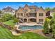Stunning backyard features a luxurious pool, stone patio, lush landscaping, and a spacious screened porch at 17909 Golden Meadow Ct, Davidson, NC 28036