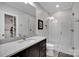 Modern bathroom featuring a glass shower, white tile, and a dark wood vanity with a light countertop at 17909 Golden Meadow Ct, Davidson, NC 28036